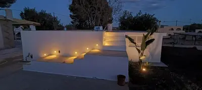 a bench with lights on the side of a white wall at Ca la Yaya in Lliria
