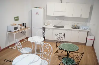 a kitchen with a table and chairs and a refrigerator at Aiora Hostel in Valencia