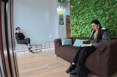 a woman sitting on a couch reading a book at Aiora Hostel in Valencia