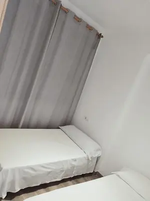 a bed in a room with a curtain at Apartamento para 5 personas en Faro de Cullera in Faro de Cullera