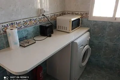 a microwave sitting on a counter next to a washing machine at Apartamento para 5 personas en Faro de Cullera in Faro de Cullera