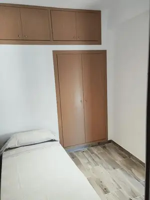 a bedroom with a bed and wooden cabinets at Apartamento para 5 personas en Faro de Cullera in Faro de Cullera