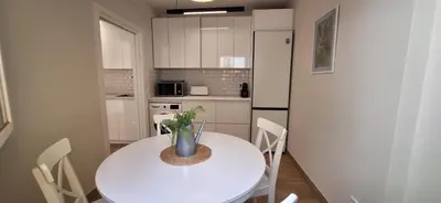 a kitchen with a white table and a white refrigerator at El Mercado in Puerto de Sagunto