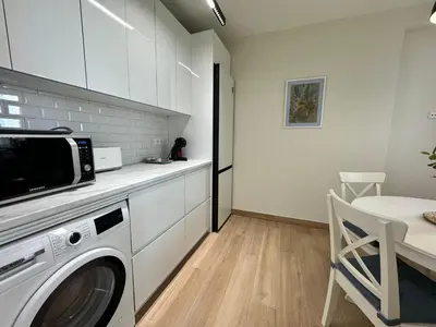 a kitchen with a washing machine and a table at El Mercado in Puerto de Sagunto