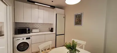 a kitchen with a table and a washing machine in it at El Mercado in Puerto de Sagunto
