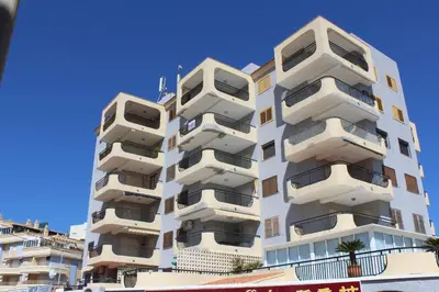 a white building with balconies on the side of it at Jardin II Solo Familias Serviplaya in Playa de Xeraco