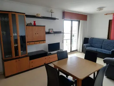 a living room with a table and a blue couch at Jardin II Solo Familias Serviplaya in Playa de Xeraco