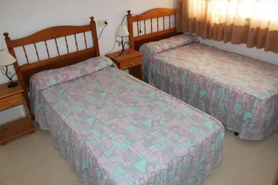 two beds in a hotel room with at Jardin II Solo Familias Serviplaya in Playa de Xeraco