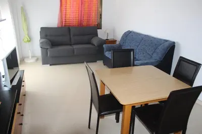 a living room with a table and a couch at Jardin II Solo Familias Serviplaya in Playa de Xeraco
