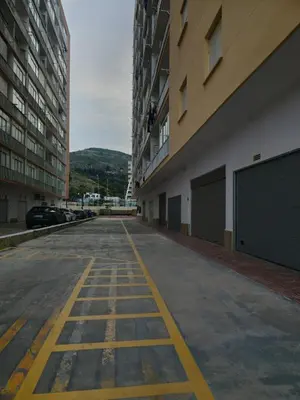 an empty parking lot between two tall buildings at Beach view apartment in Cullera in Cullera