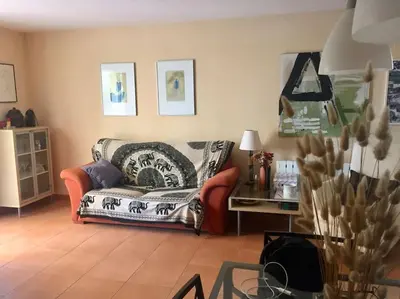 a living room with a couch and a table at Agradable adosado con piscina y jardín in Canet de Berenguer