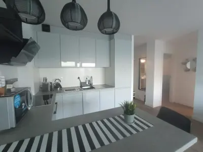 a kitchen with white cabinets and a table with a plant at Cullera Buena Vista Social Club con piscina y vistas al mar Solo Familias! in Cullera