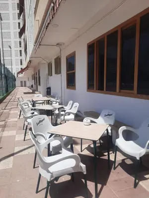 a row of tables and chairs on the side of a building at Cullera Buena Vista Social Club con piscina y vistas al mar Solo Familias! in Cullera