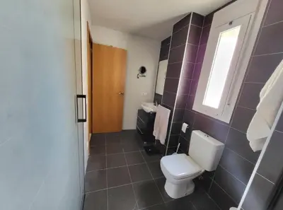 a bathroom with a toilet and a sink and a window at Luminoso ático dúplex con terraza de césped in Montroy