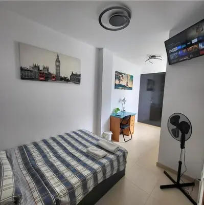 a bedroom with a bed and a flat screen tv at Luminoso ático dúplex con terraza de césped in Montroy