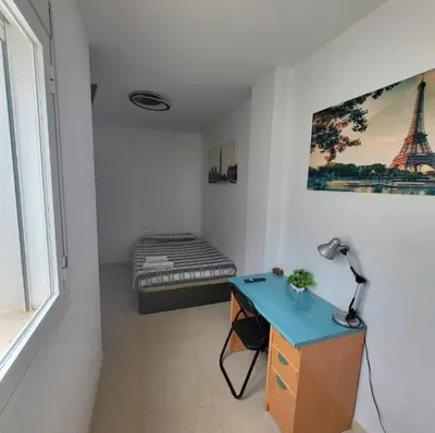 a room with a bed and a desk with a desk sidx sidx sidx at Luminoso ático dúplex con terraza de césped in Montroy
