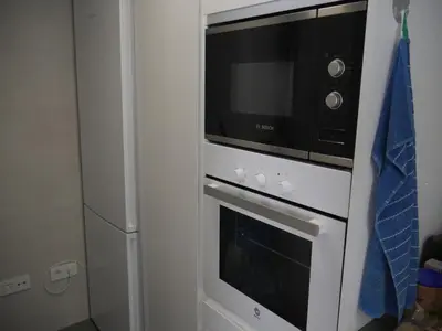 a microwave sitting on top of a oven at Bellaterra, BQ-2, BAJO A in Cullera