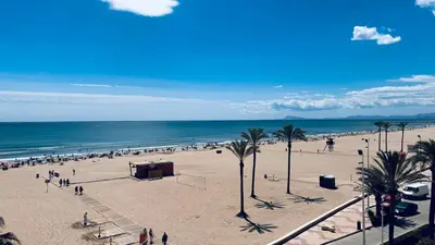 a group of people on a beach with the ocean at Apartamento primera línea playa San Antonio in Cullera