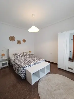 a white bedroom with a bed and a white table at Entre Mar y Montañas in Vall de Uixó