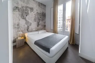 a kitchen and living room with a glass table and chairs at Mercado Central Suites in Valencia
