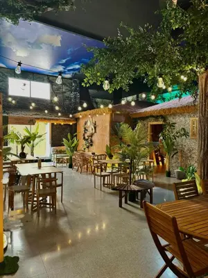 a restaurant with wooden tables and chairs and plants at The POD Suite Hostel Village in Valencia