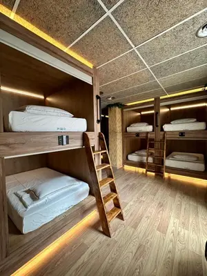 a room with three bunk beds and a ladder at The POD Suite Hostel Village in Valencia