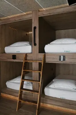 a bunk bed with a ladder and two beds at The POD Suite Hostel Village in Valencia