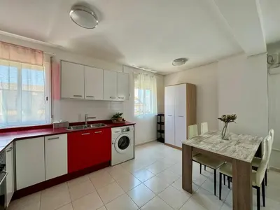 a kitchen with a table and a washing machine at Vistas al Castell de Alacuas in Alaquas