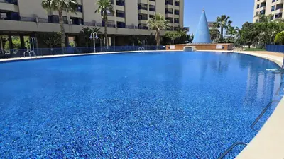 a large blue swimming pool with a fountain at BEACH VALENCIA LUXURY D15-9 Apartment with terrace and sea views with two rooms in Valencia