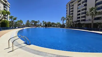 a large swimming pool in a building with palm trees at BEACH VALENCIA LUXURY D15-9 Apartment with terrace and sea views with two rooms in Valencia