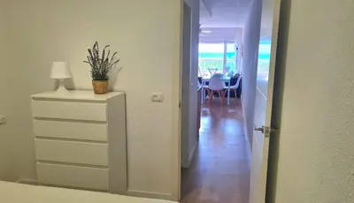 a hallway with a dresser and a room with a table at Vista Mar Apartamento Playa Farnals in Playa Pobla de Farnals