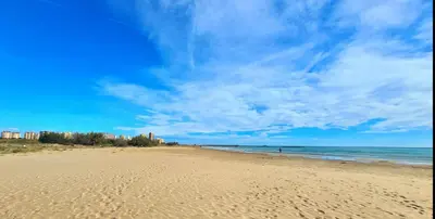 a beach with a blue sky and the ocean at Vista Mar Apartamento Playa Farnals in Playa Pobla de Farnals