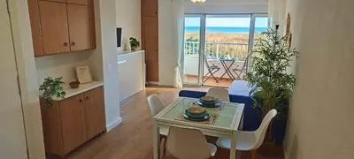 a living room with a table and chairs and a balcony at Vista Mar Apartamento Playa Farnals in Playa Pobla de Farnals
