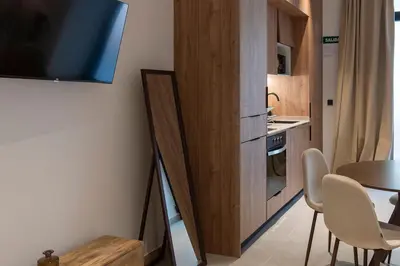 a small kitchen with a table and a tv on a wall at VLC HOST - Zapadores in Valencia