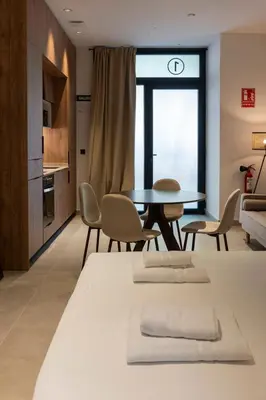 a room with two beds and a table and chairs at VLC HOST - Zapadores in Valencia