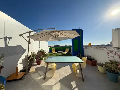 a patio with a table and an umbrella on a balcony at Petite Penthouse with the sunniest terrace in Valencia in Valencia