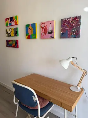 a desk with a lamp and paintings on the wall at Petite Penthouse with the sunniest terrace in Valencia in Valencia