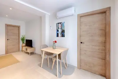 a dining room with a table and a wooden door at Portal de Ruzafa 1 in Valencia