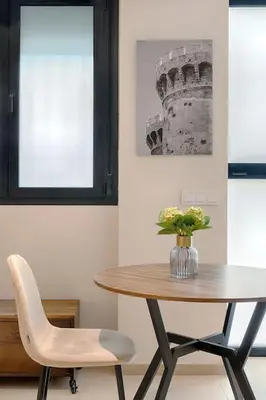 a table and a chair with a vase of flowers at Portal de Ruzafa 2 in Valencia