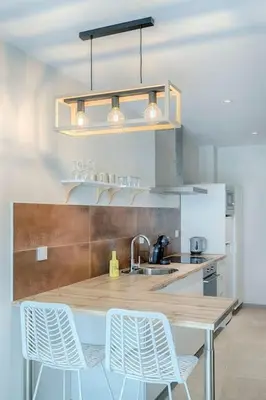 a kitchen with a wooden table and white chairs at Ruzafa´s Gate 3 in Valencia
