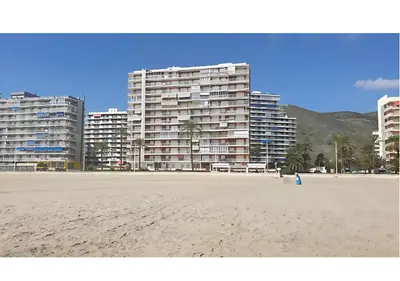 a sandy beach with tall buildings in the background at El balcón del mar - 1ª línea y frontal al mar in Cullera
