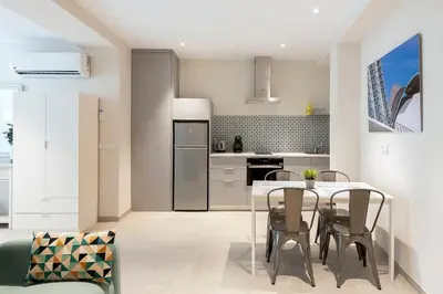 a kitchen with a table and chairs in a room at Portal de Ruzafa 4 in Valencia