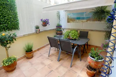 a patio with a table and chairs and potted plants at Lovely apartment near the beach & City of Arts and Sciences in Valencia