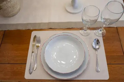 a table with a plate and two wine glasses at Lovely apartment near the beach & City of Arts and Sciences in Valencia