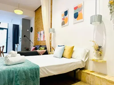 a bedroom with a bed and a couch at Relaxing BeachSide Cabanyal Loft in Valencia