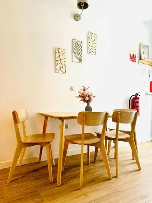 a dining room table with four chairs and a vase with flowers at Relaxing BeachSide Cabanyal Loft in Valencia