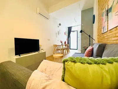 a living room with a couch and a flat screen tv at Relaxing BeachSide Cabanyal Loft in Valencia