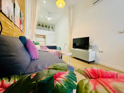 a living room with a couch and a tv at Relaxing BeachSide Cabanyal Loft in Valencia