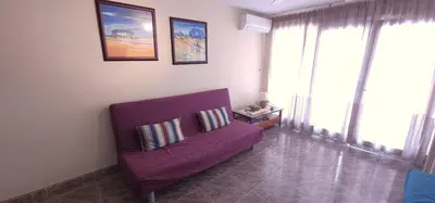 a purple couch in a living room with windows at Vacansis Sant Germein in Cullera