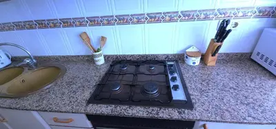a stove top in a kitchen next to a sink at Vacansis Sant Germein in Cullera